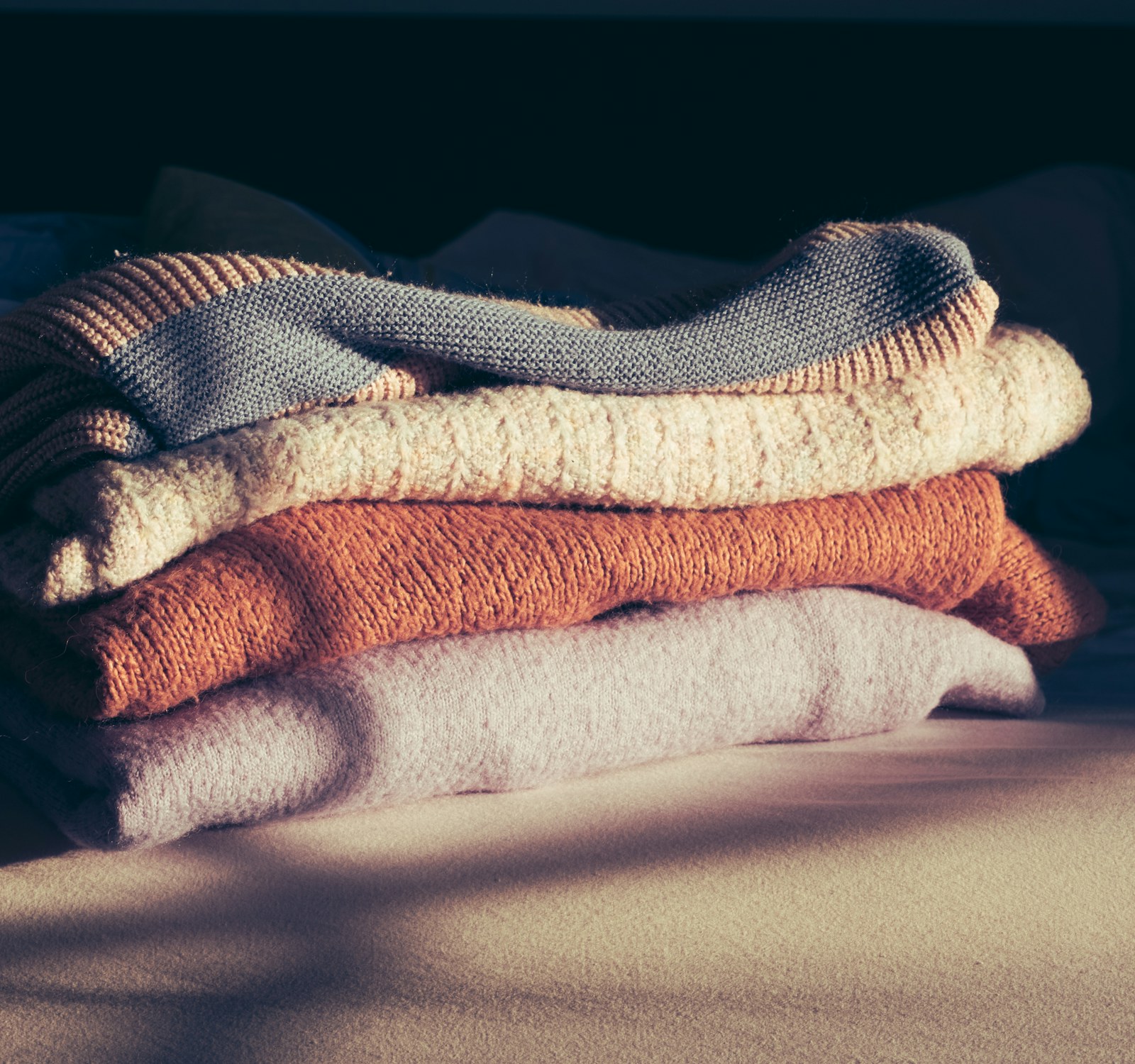 A stack of folded towels and linens in soft daylight